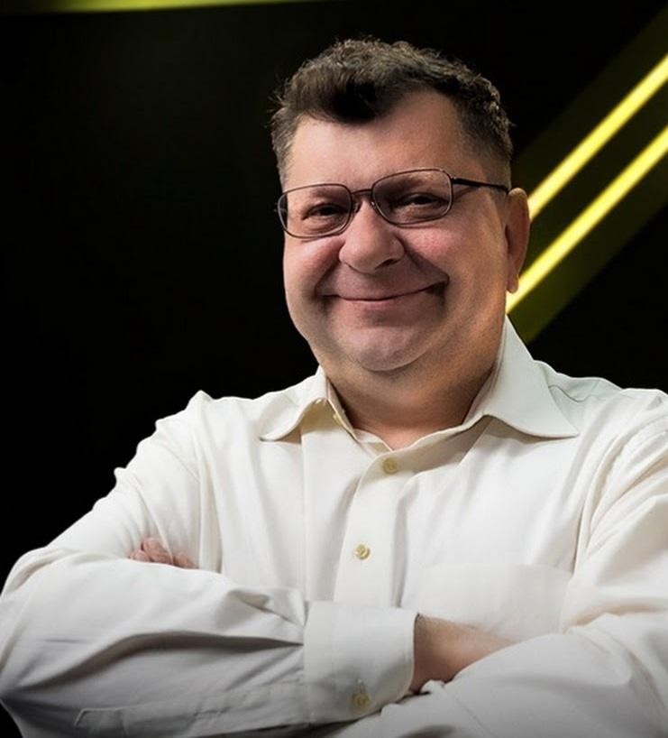 Zbigniew Stonoga podczas publicznego wystąpienia, z ekspresyjnym gestem, symbolizujący jego aktywność polityczną i medialną.