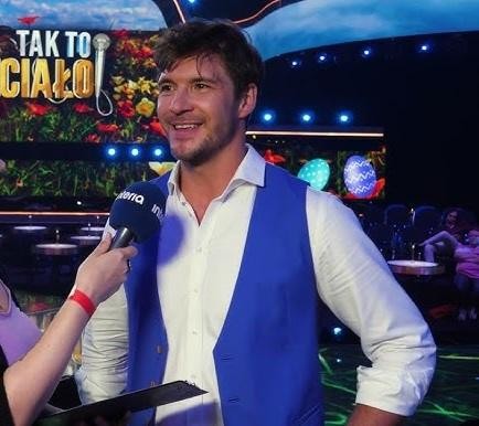 Mikołaj Roznerski w zamyśleniu, portret podkreślający jego osobiste doświadczenia.