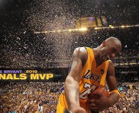 Kobe Bryant w akcji meczowej, biegnący z piłką w koszulce Lakers, z pełną determinacji twarzą.