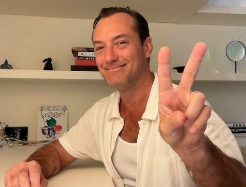 Jude Law w dynamicznej scenie, wcielający się w jedną ze swoich ikonicznych ról filmowych lub teatralnych.
