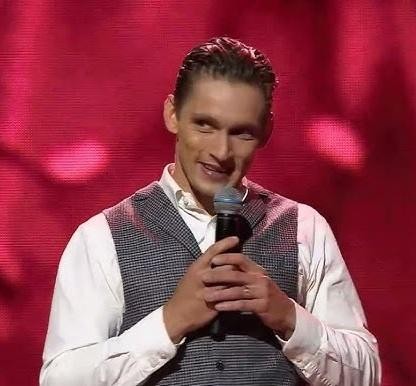 Filip Gurłacz w dynamicznej pozie na planie filmowym, wyrażający intensywne emocje, co podkreśla jego talent aktorski i zaangażowanie w karierę zawodową.