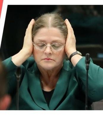 Krystyna Pawłowicz podczas publicznego wystąpienia, z ekspresyjną mimiką i gestykulacją.