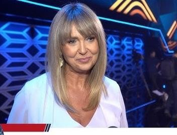Ewa Wachowicz prowadząca warsztaty kulinarne, gestykulująca przy daniu, otoczona uczestnikami.