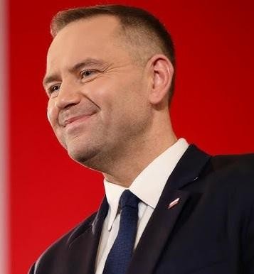 Karol Nawrocki w trakcie publicznego wystąpienia lub spotkania, aktywnie angażujący się w dyskusję.