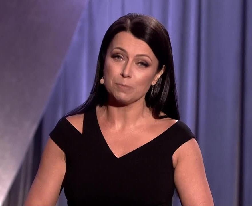 Adrianna Borek w dynamicznej pozie na scenie, wykonująca skecz, z charakterystyczną mimiką i gestykulacją, oddającą jej talent komediowy.