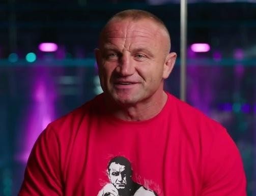 Mariusz Pudzianowski walczący w oktagonie KSW, w dynamicznej akcji podczas walki MMA.