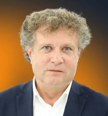 Jacek Karnowski żeglujący na jachcie, z uśmiechem na twarzy, na tle morza.