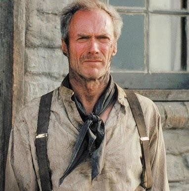 Clint Eastwood jako reżyser na planie filmowym, zamyślony, w otoczeniu ekipy i sprzętu filmowego.